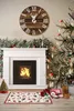 A cozy Christmas scene with a fireplace, Christmas tree, and festive decorations. Podgląd zdjęcia produktu