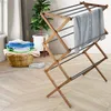 A wooden drying rack with clothes is shown in a room with a plant and laundry basket. Anteprima dell’immagine prodotto
