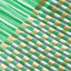 A close-up abstract view of a woven material with green, yellow, and white strands. Anteprima dell’immagine prodotto