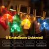A string of colorful butterfly-shaped LED lights hanging on a clothesline with clothespins. Produktbild-Vorschau