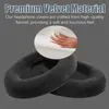 Close-up of black headphone ear pads with a hand pressing into a white cushion. Produktbild-Vorschau