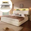 A bedroom scene featuring a modern bed with a lit headboard and a smaller inset image showing the bed's storage mechanism. Náhled obrázku produktu