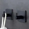 Two black adhesive hooks mounted on a textured gray wall. Anteprima dell’immagine prodotto