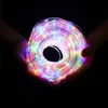 Hands holding a coiled string of colorful LED lights against a black background. Produktbild-Vorschau