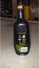 A black bottle of Passoa liqueur is shown on a concrete floor, with shelves of products in the background. Produktbild-Vorschau