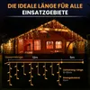 A wooden cabin decorated with icicle lights at night. Produktbild-Vorschau