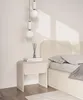 A minimalist bedroom scene featuring a nightstand and bed. Anteprima dell’immagine prodotto