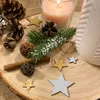 A close-up of Christmas decorations including pine cones, a candle, a cinnamon stick, and glittery star ornaments arranged on a wooden slice. Produktbild-Vorschau