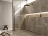 A modern bathroom with a marble-tiled shower and a wooden stool. Produktbild-Vorschau