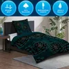A bed with a duvet and pillow featuring a floral pattern, set in a bedroom environment with a plant and nightstand. Produktbild-Vorschau