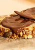 A close-up shot of a slice of bread topped with chocolate spread and a knife. Produktbild-Vorschau