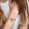 A person's arm wearing a charm bracelet with a heart and paw print charm. Anteprima dell’immagine prodotto