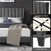 A collage of images showcasing a dark gray upholstered bed frame with a tall, fluted headboard. The collage includes close-ups of the headboard, the metal and wood bed frame construction, and the solid support feet. A portion of the bed with pillows and a  Podgląd zdjęcia produktu