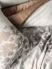 A close-up view of bedding with a floral leaf pattern. Produktbild-Vorschau