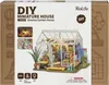 The image shows the packaging of a DIY miniature house kit, featuring an illustration of the assembled greenhouse model and various icons. Anteprima dell’immagine prodotto