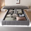 A bed with its storage compartment open, revealing neatly folded bedding and pillows. The bed is in a bedroom setting with nightstands and decor in the background. Náhled obrázku produktu