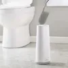 A toilet brush and holder are shown next to a toilet. Náhled obrázku produktu