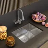 A modern kitchen sink area with a flexible faucet, a bowl of figs, and a jar of pistachios. Produktbild-Vorschau