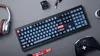 A flat lay of a keyboard, headphones, and a game controller on a gray surface. Produktbild-Vorschau