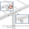 Close-up view of a person assembling a white metal bed frame, showing how L-shaped plates are used for fastening. Produktbild-Vorschau