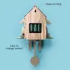 The back of a wooden cuckoo clock with batteries installed, against a light blue background. Voir les images du produit