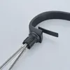 Close-up view of a black faucet with water hoses attached. Podgląd zdjęcia produktu