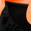 Close-up view of the interior lining and seams of an orange and black garment. Produktbild-Vorschau