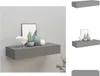 A gray floating shelf mounted on a light gray wall, decorated with a framed picture, a potted plant, and two vases. Produktbild-Vorschau