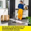 A woman is cleaning a floor with a steam mop in a modern kitchen/hallway setting. Voir les images du produit