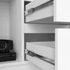 Close-up of a white cabinet with open drawers and a black electronic device on a shelf. Produktbild-Vorschau