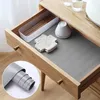 A drawer lined with a gray mat, containing a white organizer with chopsticks, a knitted coaster, and a small white bowl. Náhled obrázku produktu