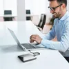A man is working on a laptop with an external DVD drive connected. Produktbild-Vorschau
