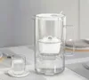 A glass water pitcher with a filter and a glass of water on a table. Podgląd zdjęcia produktu