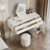A white vanity table with a lighted mirror, drawers, and a cabinet, set in a modern bedroom with a stool. Voir les images du produit