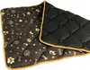 A quilted pet mat with a brown side featuring paw prints and bones, and a black side. Náhled obrázku produktu