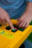 A person's hands are shown operating the controls of a yellow garden shredder. Produktbild-Vorschau