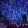 A tree decorated with blue LED meteor shower lights at night. Produktbild-Vorschau