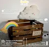 A wooden crate with toys and decorative items, featuring product information overlays. Produktbild-Vorschau