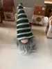 A small gnome figure with a striped hat and a long gray beard is in the foreground, with several decorative gingerbread house-shaped boxes in the background. Produktbild-Vorschau