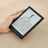 A hand holding a black Boox e-reader on a wooden surface. Produktbild-Vorschau