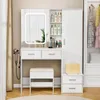 A white vanity set with a mirror, drawers, shelves, and a stool, placed in a room. Náhľad obrázku produktu