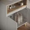 A close-up view of a white and wood-toned bathroom vanity cabinet with its doors open, revealing various toiletries inside. Náhled obrázku produktu
