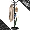 A black coat rack with a marble base, a beige coat, a blue cap, and a green umbrella. Anteprima dell’immagine prodotto
