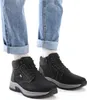 A person wearing blue jeans and black boots. Produktbild-Vorschau