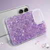A close-up shot of a glittery purple phone case with a clear border, placed on a light purple and white surface. The back of a phone is visible behind the case. Produktbild-Vorschau