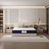 A bedroom scene with a mattress on a bed frame. Voir les images du produit