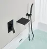 A black built-in bathtub faucet with a waterfall spout and a handheld showerhead is shown mounted on a light gray wall above a white bathtub filled with water. Podgląd zdjęcia produktu