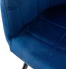 A close-up view of a dark blue velvet dining chair. Náhled obrázku produktu