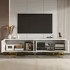 A modern living room setup featuring a white TV stand with gold accents and a large television mounted on the wall. Produktbild-Vorschau