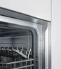 Close-up view of the interior of a dishwasher, showing racks and a metal frame. Produktbild-Vorschau